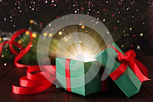 Beautiful Christmas gift box with magic light on table