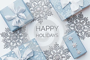 Beautiful christmas gifts and silver snowflakes isolated on white background. Pastel blue colored wrapped xmas boxes.