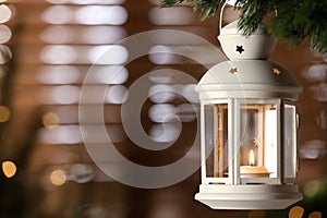 Beautiful Christmas lantern with burning candle hanging on fir tree branch in room. Space for text