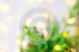 Beautiful Christmas New Year Blurred Background. Decorated fir tree branches golden garland bokeh lights. Festive atmosphere