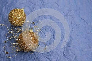 Beautiful Christmas and New Year composition with golden decorations on trendy blue background made with textured paper. Festive