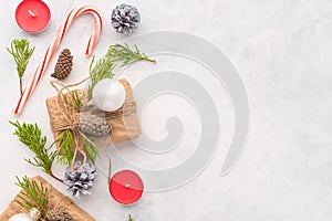 Beautiful Christmas and New Year composition. On a white background gifts, cones, toys, sweets and coniferous branches. Minimalism