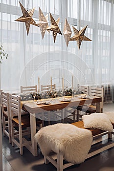 Beautiful Christmas serving table with candles and fir-tree decoration at cozy modern interior