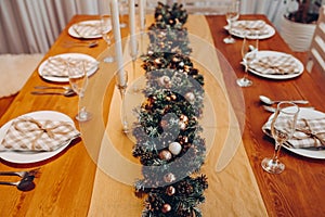 Beautiful Christmas serving table with candles and fir-tree decoration at cozy modern interior