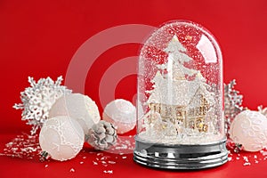 Beautiful Christmas snow globe and festive decor on red background