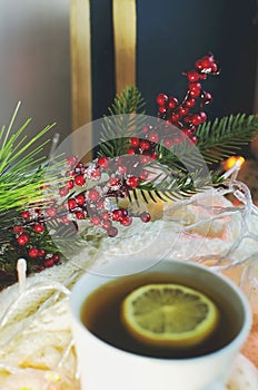 Beautiful Christmas still life on the windowsill. Festive background. Lemon tea, New Year`s decorations, festive garland. Soft