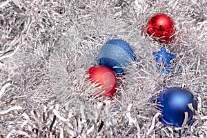 Beautiful Christmas toys of blue and red colors on tinsel