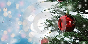 Beautiful Christmas tree with bright baubles against blurred lights on light blue background, closeup. Banner design with space