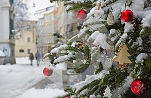 Beautiful Christmas tree detail and blurred people walking through the snow in winter day, in the city center of Graz, Steiermark