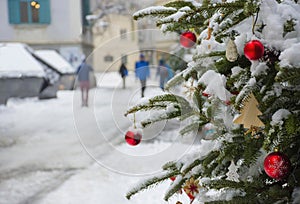 Beautiful Christmas tree detail and blurred people walking through the snow in winter day, in the city center of Graz, Steiermark