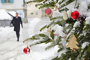 Beautiful Christmas tree detail and blurred people walking through the snow in winter day, in the city center of Graz, Steiermark