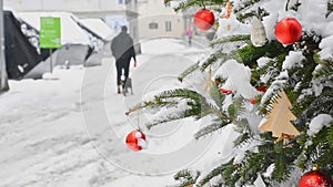 Beautiful Christmas tree detail and blurred people walking through the snow in winter day, in the city center of Graz, Steiermark