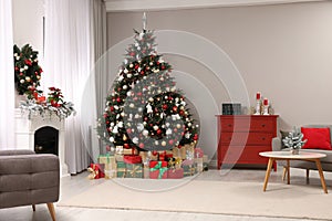 Beautiful Christmas tree and gifts near fireplace in festively decorated living room