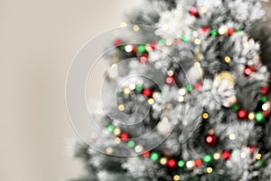 Beautiful Christmas tree with lights against grey background, blurred view
