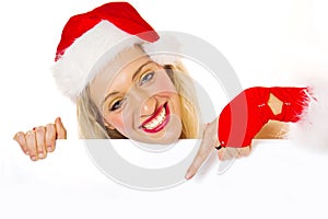 Beautiful christmas woman in santa hat holding empty board