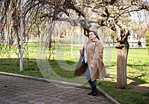 Beautiful chubby girl in a beige raincoat