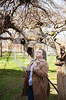 Beautiful chubby girl in a beige raincoat