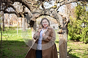 Beautiful chubby girl in a beige raincoat