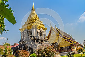Beautiful church and golden Lanna-style chedi supported by rows of elephant-shaped buttresses at Wat Chiang Man, oldest temple in