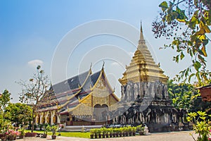 Beautiful church and golden Lanna-style chedi supported by rows of elephant-shaped buttresses at Wat Chiang Man, oldest temple in