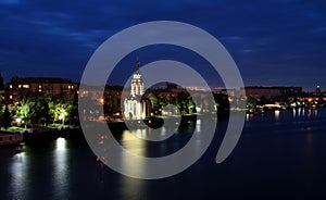 Beautiful church with illuminating at night, lights reflected in the water. View of the Dnipropetrovsk Embankment , Ukraine