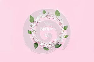 A beautiful circle of lilac flowers and leaves in the center of the inscription happy mothers day