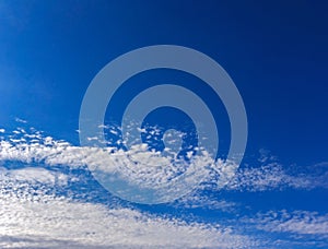 Beautiful cirrus fluffy clouds on a blue sky background