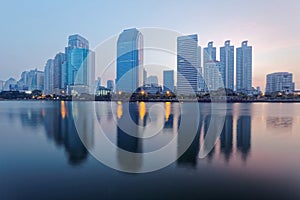 Beautiful city skyline of Bangkok at dawn with lakeside skyscrapers and reflections