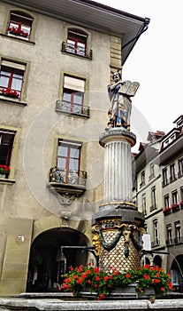 Beautiful City Street View of the colorful medieval Moses statue on top of elaborate fountain in Bern, Switzerland.