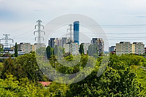 Beautiful cityscape at cloudy day with energy towers and a lot of energy lines with small trees and