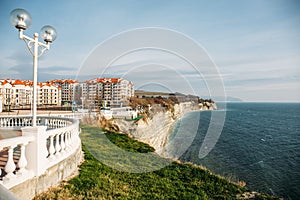 Beautiful cityscape with modern buildings on cliff coastline, blue sea and rocks, Gelendzhik, Russia