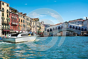 Beautiful cityscape view in Venice, Italy, with water taxi going towards de Rialto Bridge on the Grand Canal, picturesque old buil