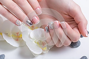 Beautiful classic French manicure with rhinestones on female hand. Close-up.