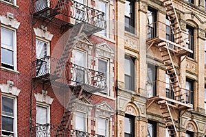 Beautiful classic New York City apartment building exterior with ornate window details and fire escapes