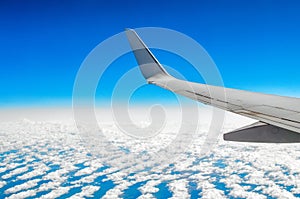 Beautiful classic view of the porthole during a flight by plane, clouds of blue sky and earth.