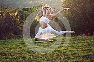 Beautiful classical dancer jumping in sunset light