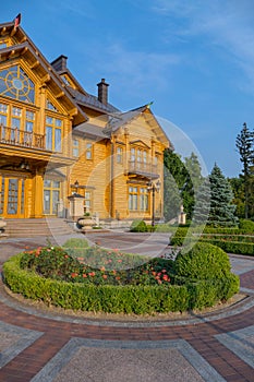Beautiful, clean courtyard in front of an elite wooden house with balconies on the blue sky background. Mezhyhirya