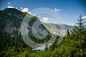 A beautiful, clean lake in the mountain valley in calm, sunny day. Mountain landscape with water in summer.