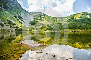 Krásné, čisté jezero v horském údolí za klidného slunečného dne. Horská krajina s vodou v létě.