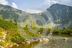 A beautiful, clean lake in the mountain valley in calm, sunny day. Mountain landscape with water in summer.