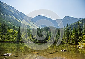 A beautiful, clean lake in the mountain valley in calm, sunny day. Mountain landscape with water in summer.