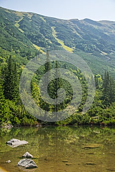 A beautiful, clean lake in the mountain valley in calm, sunny day. Mountain landscape with water in summer.