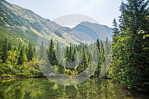 A beautiful, clean lake in the mountain valley in calm, sunny day. Mountain landscape with water in summer.