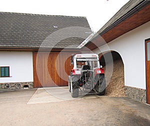 Beautiful clean tractor stands near a sawdust with a wood sawdust