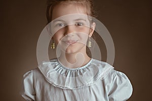 Beautiful clever pupil, little girl student, education in school, pupil, studio portrait on brown background.