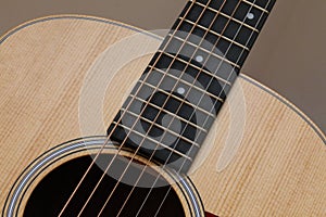 Beautiful close up abstract picture of a classical acoustic guitar with soft light brown beige natural wood grain, ebony fretboard