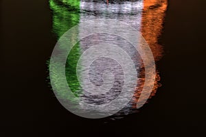 Beautiful closeup evening view of ring beam lighting of The Convention Centre Dublin reflecting in water and imitating Irish flag