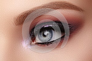 Beautiful Closeup Eye Make-up with Purple Glitter Shadows. Fashion Celebrate Makeup, Clean Skin, perfect Shapes of Brows