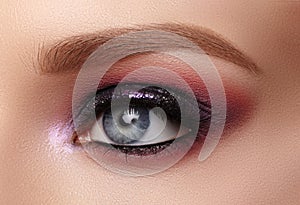 Beautiful Closeup Eye Make-up with Purple Glitter Shadows. Fashion Celebrate Makeup, Clean Skin, perfect Shapes of Brows