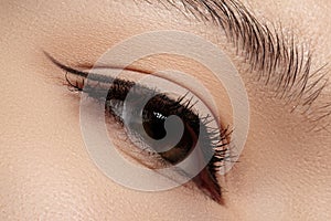 Beautiful closeup female eye with fashion black liner make-up